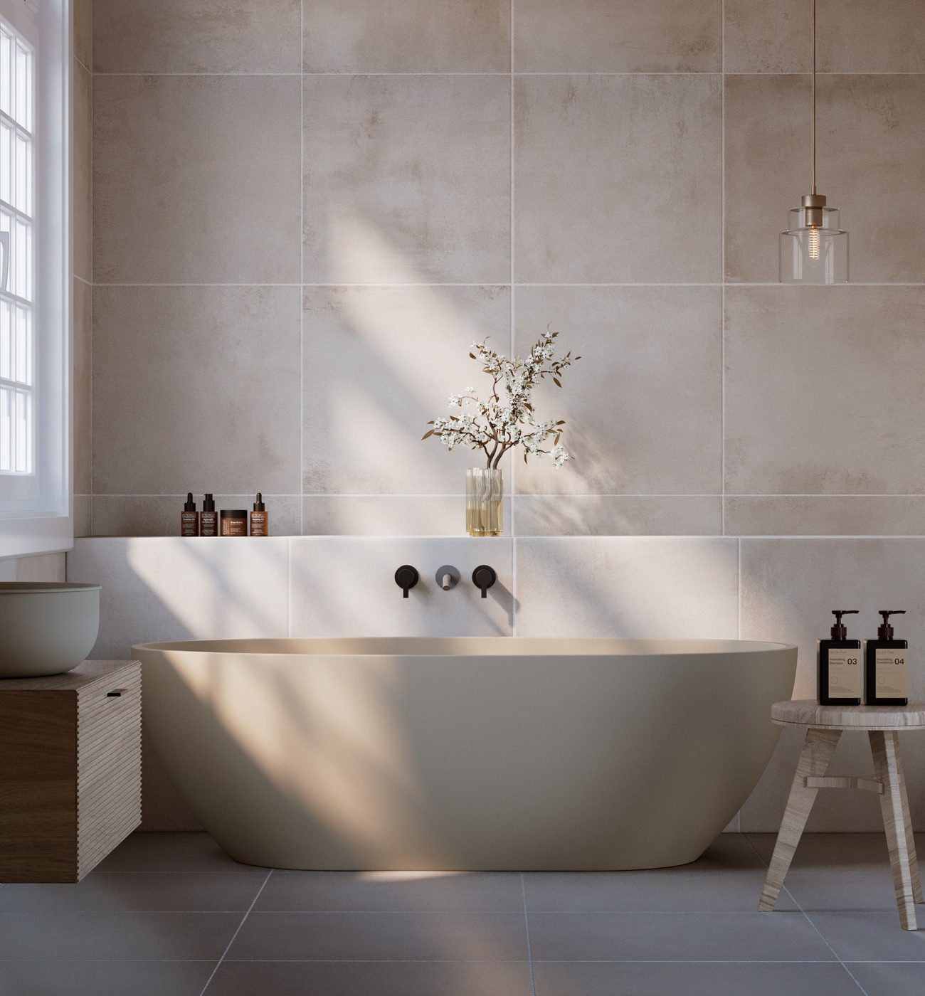 A modern bathroom with a freestanding bath, warm stone-effect tiles and a matte black wall tap